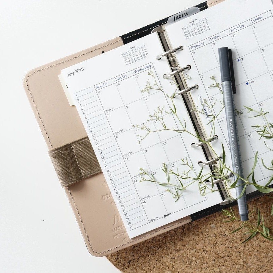 grey and black pen on calendar book